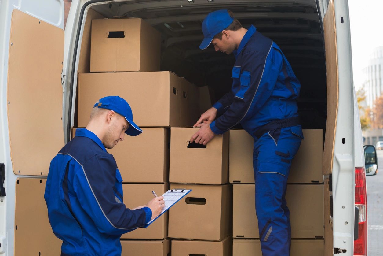 Delivery workers loading boxes into a delivery van